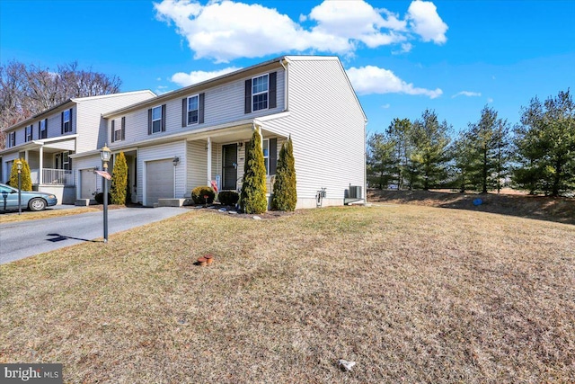 view of front of house with aphalt driveway, an attached garage, and a front lawn