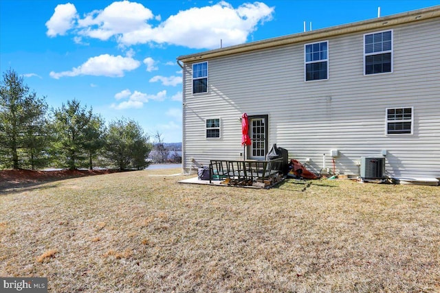 rear view of property featuring a patio area, cooling unit, and a lawn