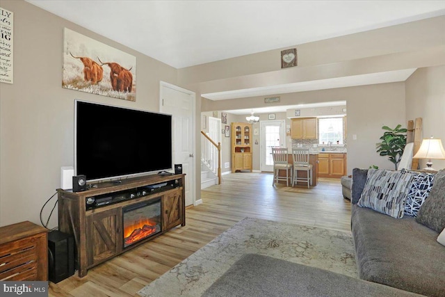 living room featuring light wood-type flooring and stairway