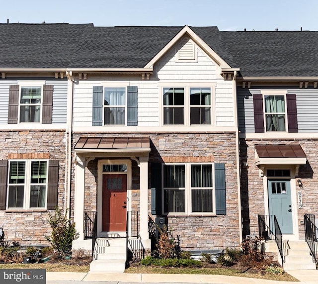 multi unit property featuring stone siding and roof with shingles