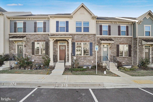 view of property featuring uncovered parking and stone siding