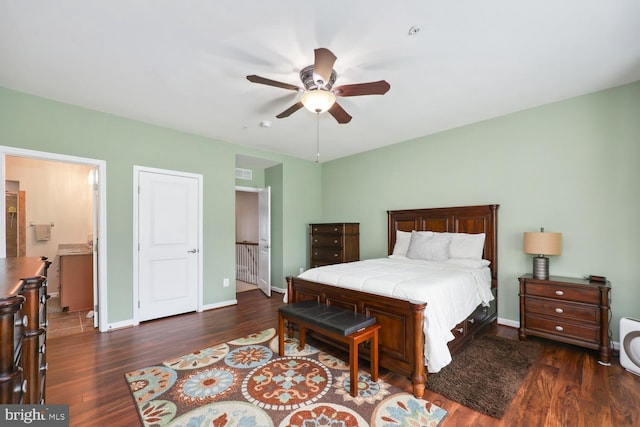 bedroom with visible vents, ceiling fan, baseboards, wood finished floors, and ensuite bath