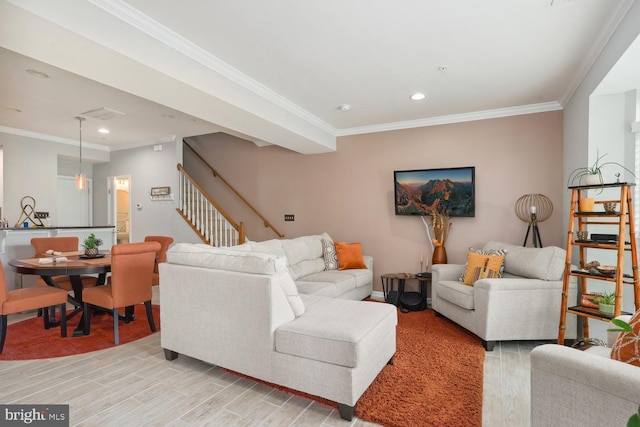 living room with stairs, ornamental molding, and light wood-style floors