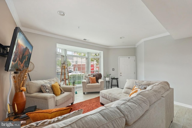 living room featuring baseboards, visible vents, ornamental molding, and light wood-style floors