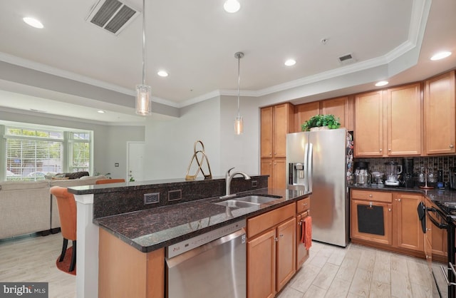 kitchen featuring crown molding, a sink, appliances with stainless steel finishes, visible vents, and open floor plan
