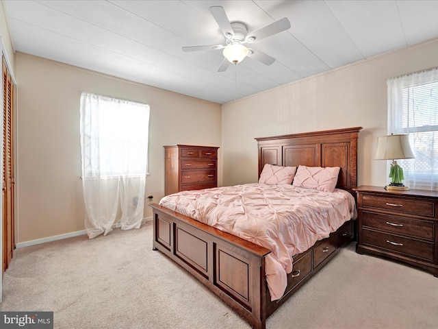 bedroom featuring baseboards, light carpet, and ceiling fan