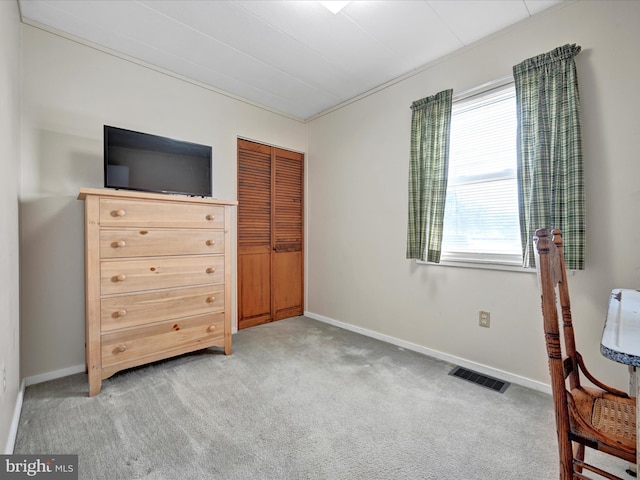 bedroom featuring a closet, visible vents, light colored carpet, and baseboards