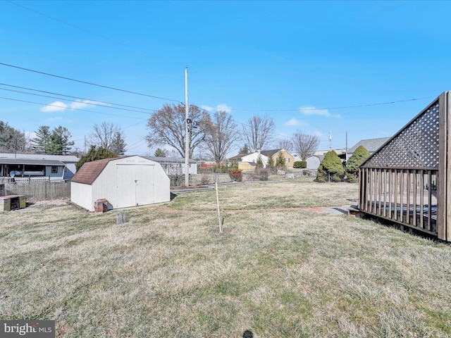 view of yard with fence, an outbuilding, and a shed