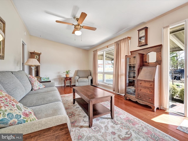 living room featuring wood finished floors, baseboards, and ceiling fan