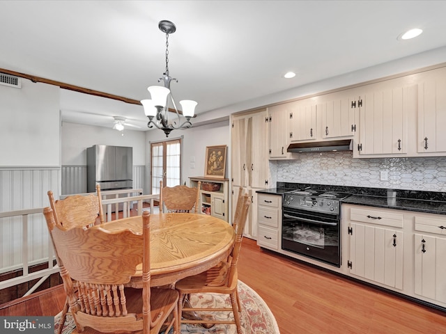 dining room featuring recessed lighting, an inviting chandelier, light wood-style flooring, and wainscoting