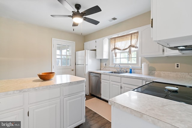 kitchen featuring visible vents, dishwasher, light countertops, white cabinets, and a sink