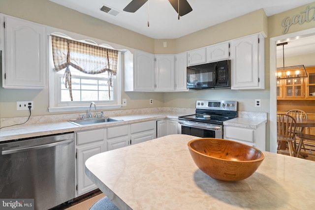 kitchen with a sink, white cabinets, visible vents, and stainless steel appliances