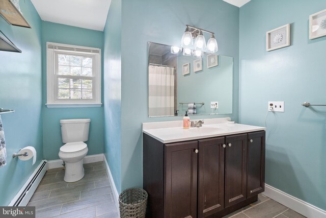 bathroom with toilet, a shower with shower curtain, baseboards, baseboard heating, and vanity