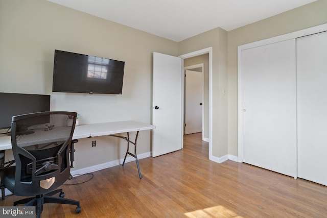 home office with baseboards and wood finished floors