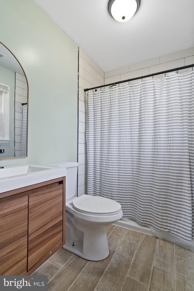 bathroom with visible vents, shower / bath combination with curtain, toilet, and vanity