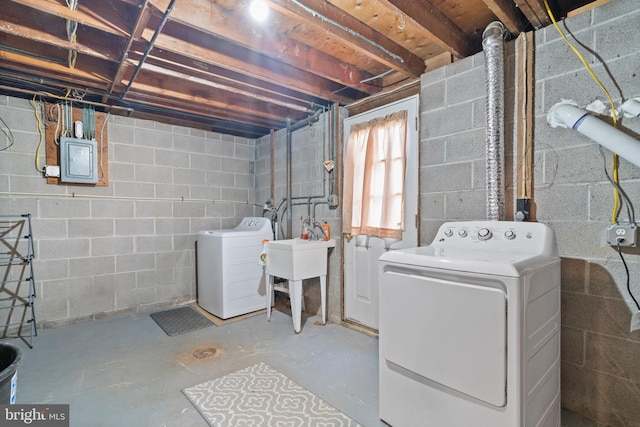 basement featuring electric panel, separate washer and dryer, and a sink