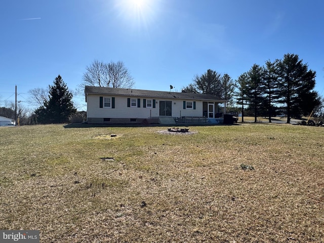 view of front facade with a fire pit and a front lawn