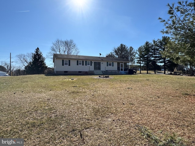 view of front of house featuring crawl space, a fire pit, and a front lawn