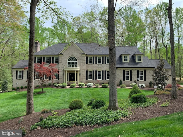 view of front of home with a front lawn and a chimney