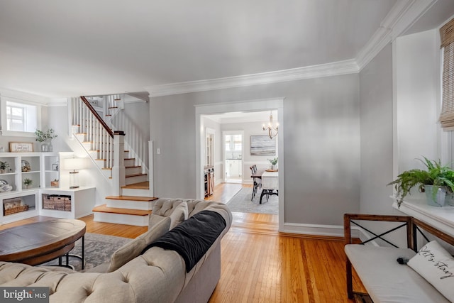 living area with a healthy amount of sunlight, stairs, light wood-style floors, and ornamental molding