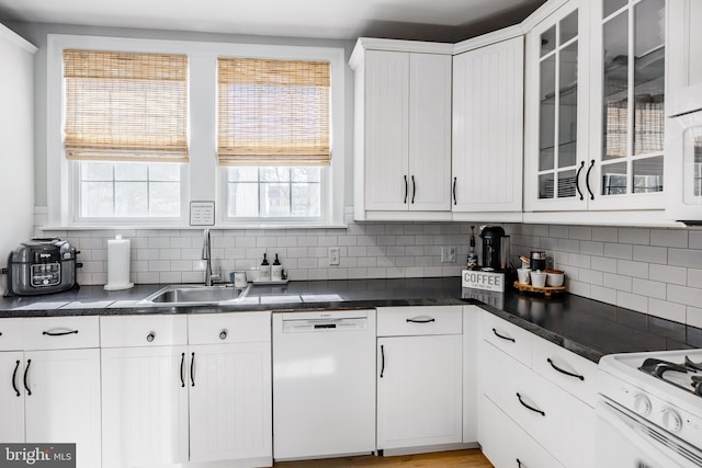 kitchen with a sink, tasteful backsplash, white appliances, white cabinets, and glass insert cabinets