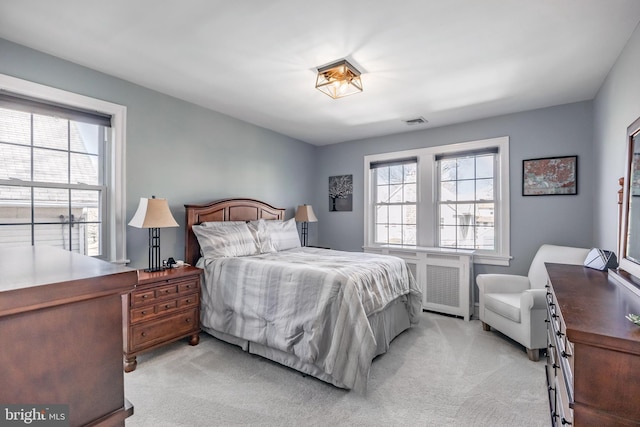 bedroom featuring multiple windows, light colored carpet, and visible vents