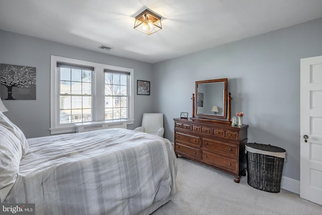 bedroom with visible vents and light carpet