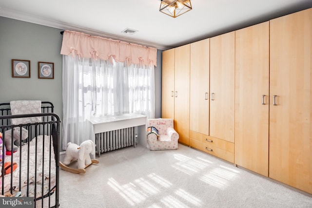 bedroom featuring visible vents, radiator heating unit, carpet floors, ornamental molding, and a nursery area