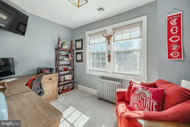 home office featuring light colored carpet, baseboards, radiator, and visible vents