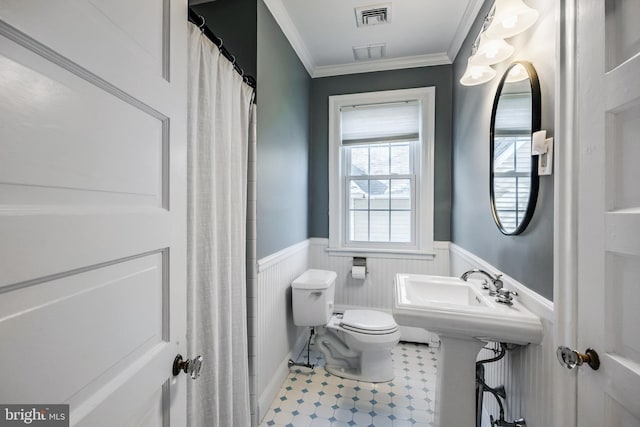 full bathroom with visible vents, toilet, crown molding, and a wainscoted wall