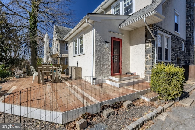 entrance to property with a patio area, outdoor dining space, and stucco siding