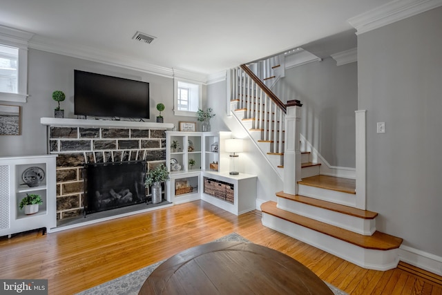 living room with visible vents, stairway, crown molding, and hardwood / wood-style flooring