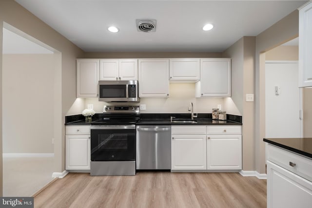 11305 Commonwealth Dr Unit 302, Rockville, MD 20852 - kitchen with appliances with stainless steel finishes, a sink, light wood-style flooring, white cabinetry, and recessed lighting