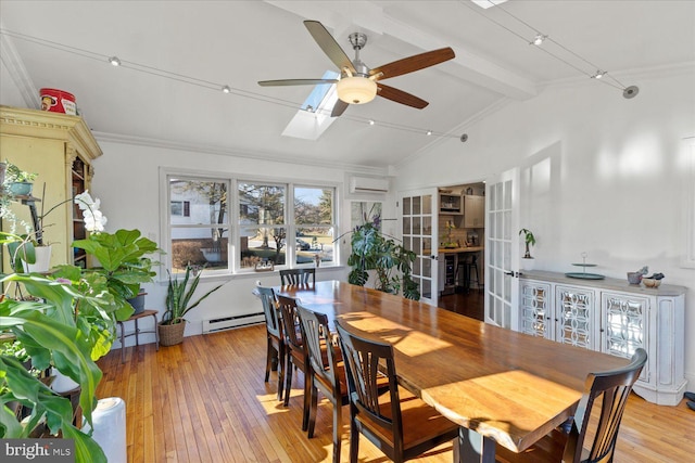 dining room featuring light wood-type flooring, lofted ceiling with skylight, a wall mounted AC, a baseboard heating unit, and french doors