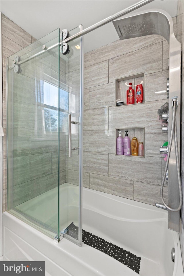 bathroom with bath / shower combo with glass door