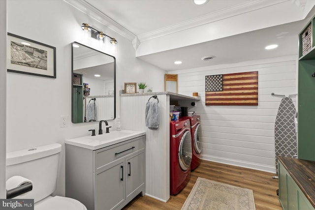 bathroom featuring visible vents, washing machine and dryer, ornamental molding, wood finished floors, and vanity