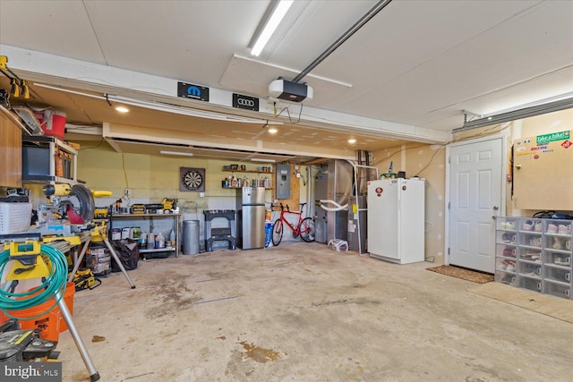 garage with a workshop area, electric panel, a garage door opener, and freestanding refrigerator