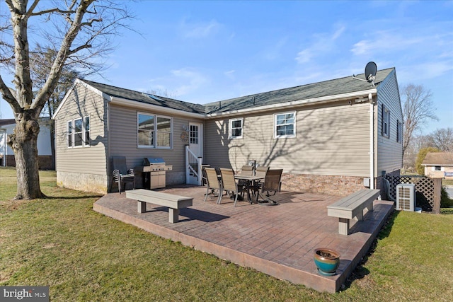 back of property with entry steps and a lawn