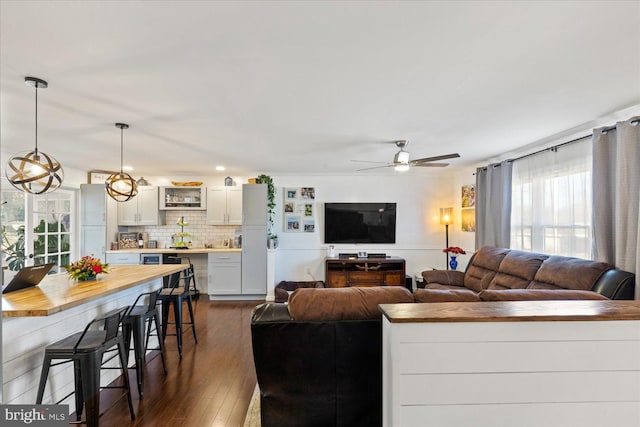 living room featuring dark wood-style floors and ceiling fan