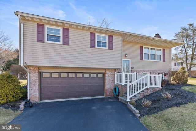 raised ranch with a garage and driveway