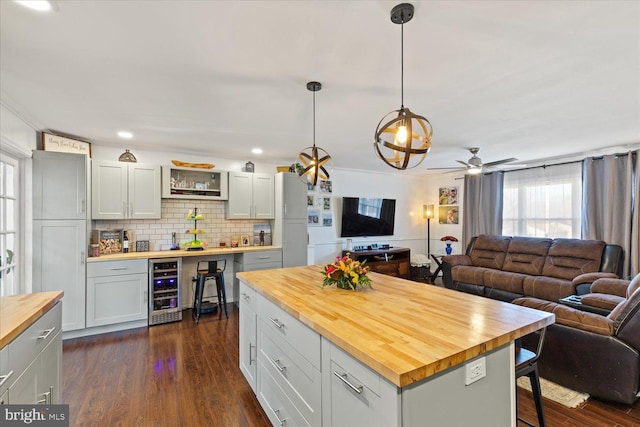 kitchen with wood counters, beverage cooler, open floor plan, and dark wood-style flooring