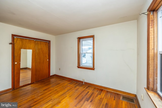 spare room with visible vents, baseboards, and hardwood / wood-style floors