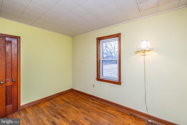 empty room with baseboards and hardwood / wood-style floors