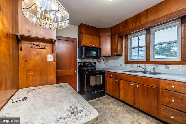 kitchen featuring brown cabinetry, black appliances, light countertops, and a sink