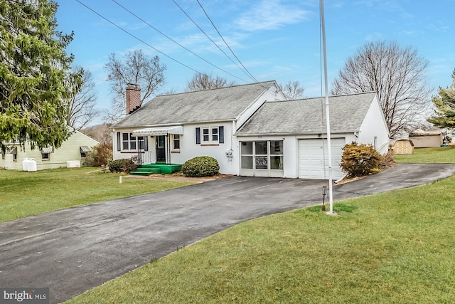 view of front of property with stucco siding, driveway, a front yard, a garage, and a chimney