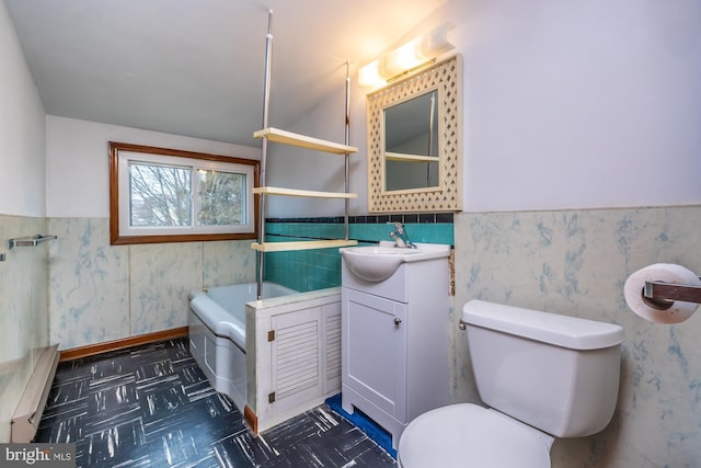 bathroom featuring a wainscoted wall, toilet, and wallpapered walls