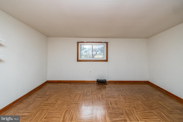 unfurnished room with baseboards