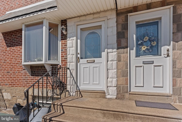 view of exterior entry with stone siding and brick siding