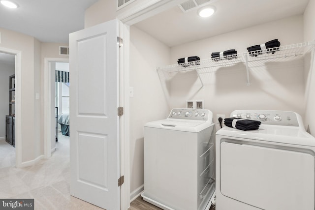 washroom featuring visible vents, baseboards, washing machine and dryer, and laundry area