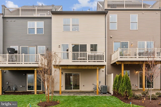 rear view of property featuring central air condition unit, a patio, and a yard